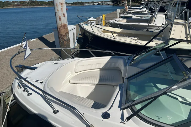 Slide: The Image of 2006 Boston Whaler 210 Ventura docked, showcasing sleek design and spacious seating. - 5