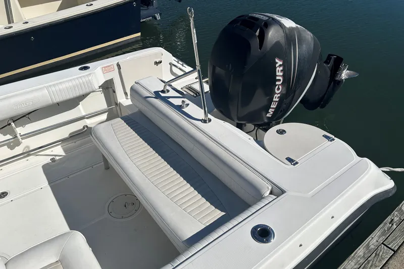 Slide: The Image of 2006 Boston Whaler 210 Ventura boat with Mercury engine, docked on calm water. - 8