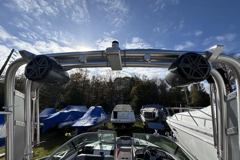 Slide: The Image of 2012 MasterCraft X-15 boat with tower speakers, parked among other boats under a sunny sky. - 11