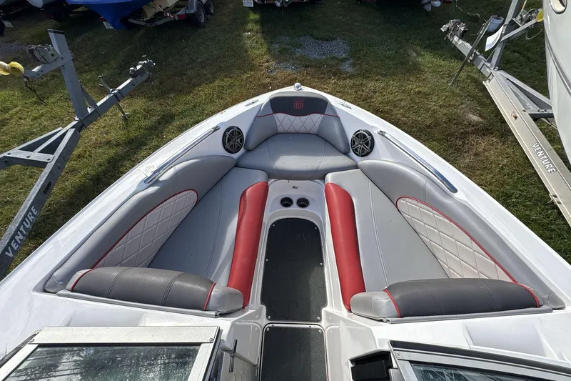 Slide: The Image of 2012 MasterCraft X-15 boat interior with red and gray seating, on a grassy area. - 3