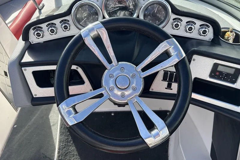 Slide: The Image of Steering wheel and dashboard of 2012 MasterCraft X-15 boat, featuring gauges and controls. - 7