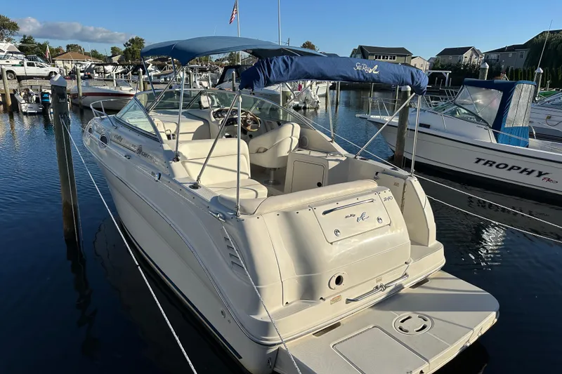 Slide: The Image of 2001 Sea Ray 240 Sundancer boat docked in a marina under clear blue skies. - 0