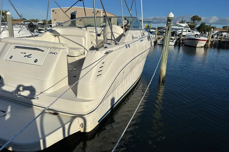 Slide: The Image of 2001 Sea Ray 240 Sundancer boat docked in a marina under clear blue skies. - 1