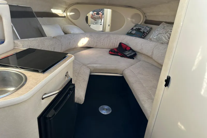 Slide: The Image of 2001 Sea Ray 240 Sundancer cabin interior with kitchenette and seating area. - 11