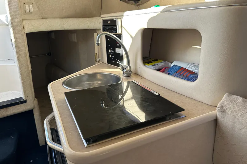 Slide: The Image of 2001 Sea Ray 240 Sundancer cabin interior with sink and storage area. - 12