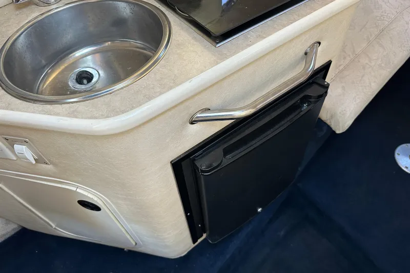 Slide: The Image of 2001 Sea Ray 240 Sundancer kitchenette with sink and mini fridge. - 16