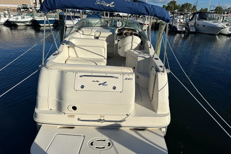Slide: The Image of 2001 Sea Ray 240 Sundancer boat docked in marina, rear view with canopy. - 3