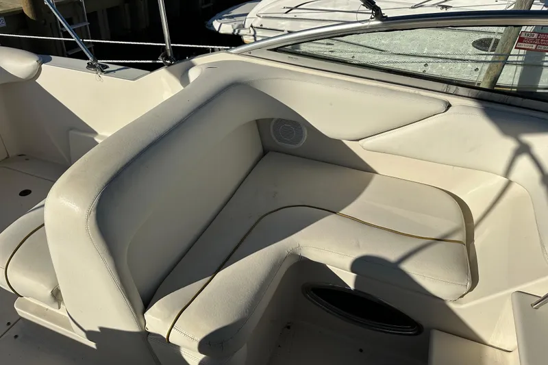 Slide: The Image of 2001 Sea Ray 240 Sundancer boat interior with white seating and speaker. - 5