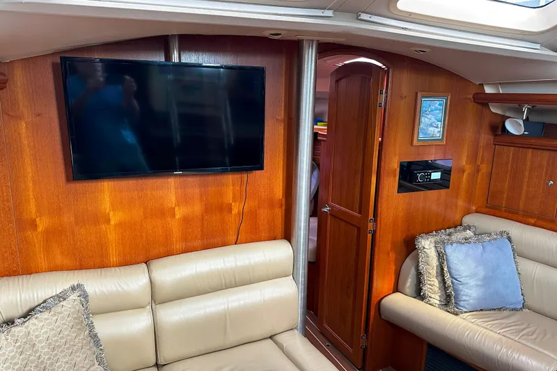 Slide: The Image of Interior of 2006 Hunter 45 CC yacht with TV, leather seating, and wooden paneling. - 18