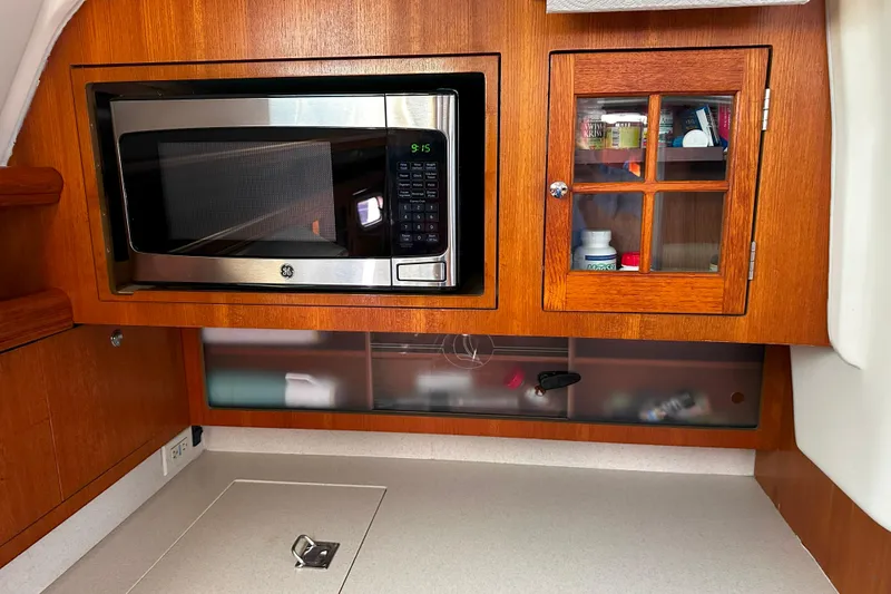 Slide: The Image of Interior of 2006 Hunter 45 CC yacht with microwave and wooden cabinets. - 28