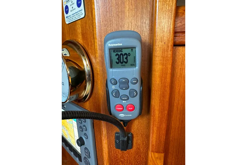 Slide: The Image of Raymarine autopilot control on 2006 Hunter 45 CC yacht, displaying heading of 303 degrees. - 43