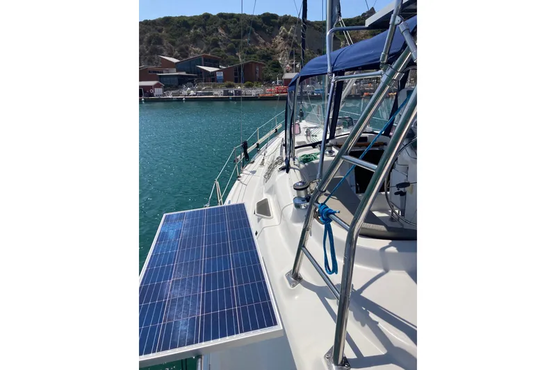 Slide: The Image of Sailboat Hunter 45 CC (2006) with solar panel, docked in a scenic marina. - 48