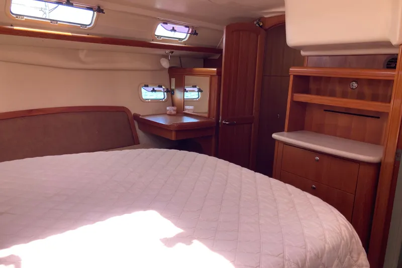 Slide: The Image of Interior of 2006 Hunter 45 CC sailboat cabin with bed, wooden cabinetry, and windows. - 7