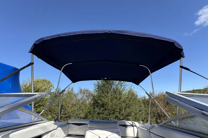 Slide: The Image of 2007 Four Winns 200 Horizon boat with blue canopy under clear sky. - 15