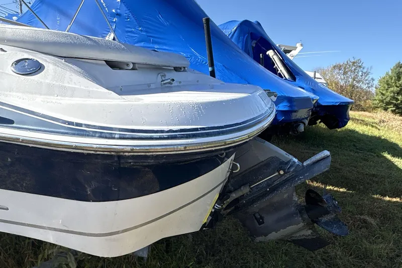 Slide: The Image of 2007 Four Winns 200 Horizon boat, partially covered, on grass with blue tarps in background. - 5