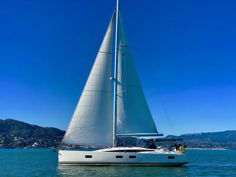 Slide: The Image of 2016 Jeanneau 54 sailboat on calm water with clear blue sky. - 2