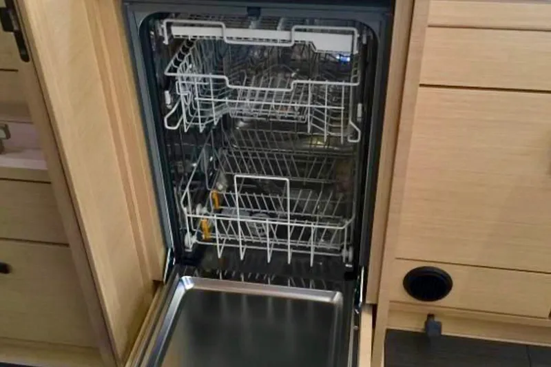 Slide: The Image of Open dishwasher in Jeanneau 54 yacht kitchen, showcasing interior racks and modern design. - 27