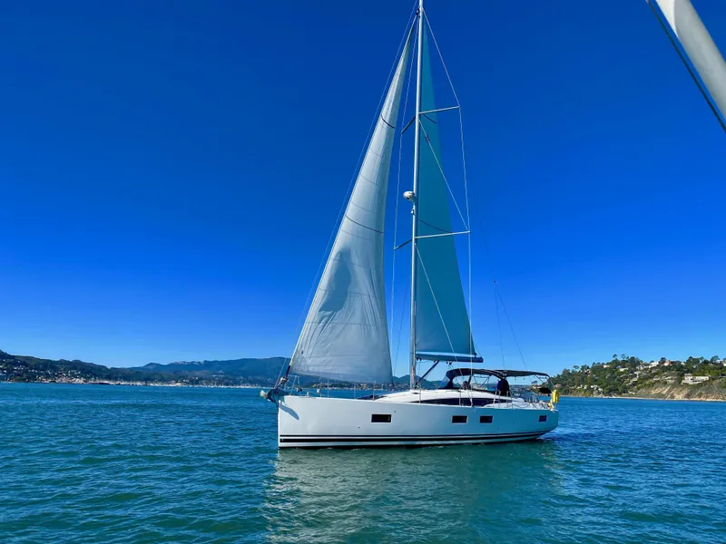 Slide: The Image of 2016 Jeanneau 54 sailboat on calm blue waters under clear skies. - 3