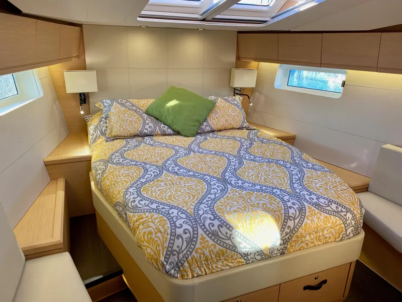 Slide: The Image of Luxurious cabin interior of a 2016 Jeanneau 54 yacht with elegant bedding and natural light. - 34