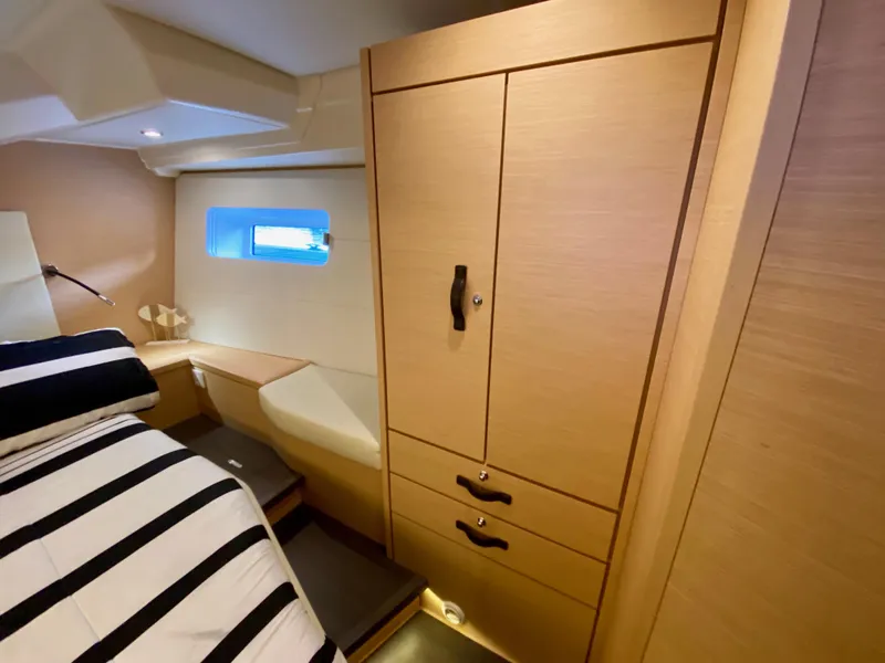 Slide: The Image of Luxurious cabin interior of 2016 Jeanneau 54 yacht with striped bedding and wooden cabinetry. - 43