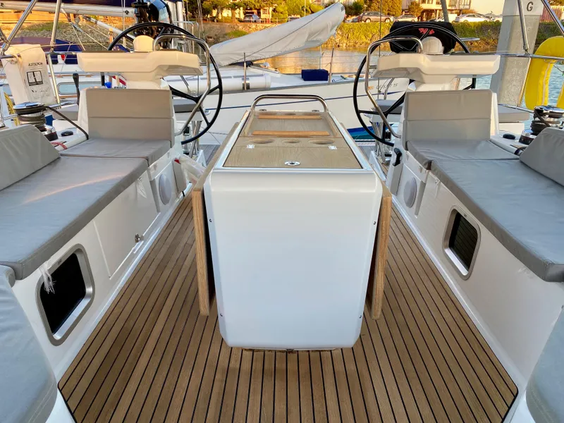 Slide: The Image of Jeanneau 54 sailboat cockpit, 2016 model, featuring dual steering wheels and teak flooring. - 8