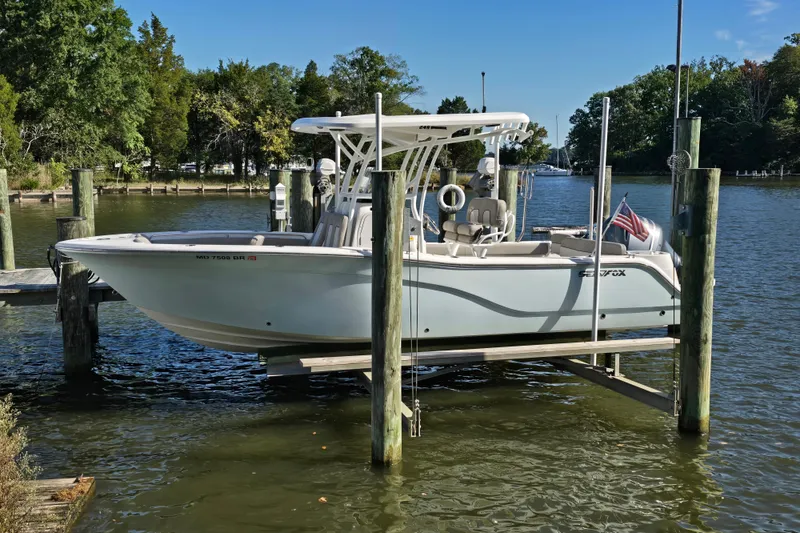 Slide: The Image of 2022 Sea Fox 249 Avenger boat docked on a lift in a scenic river setting. - 4