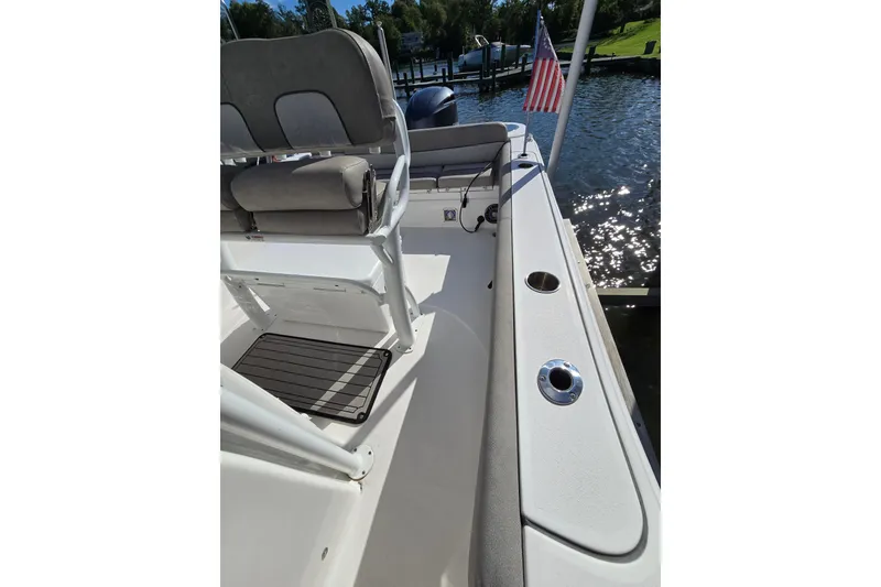 Slide: The Image of 2022 Sea Fox 249 Avenger boat interior with seating and American flag by the water. - 42