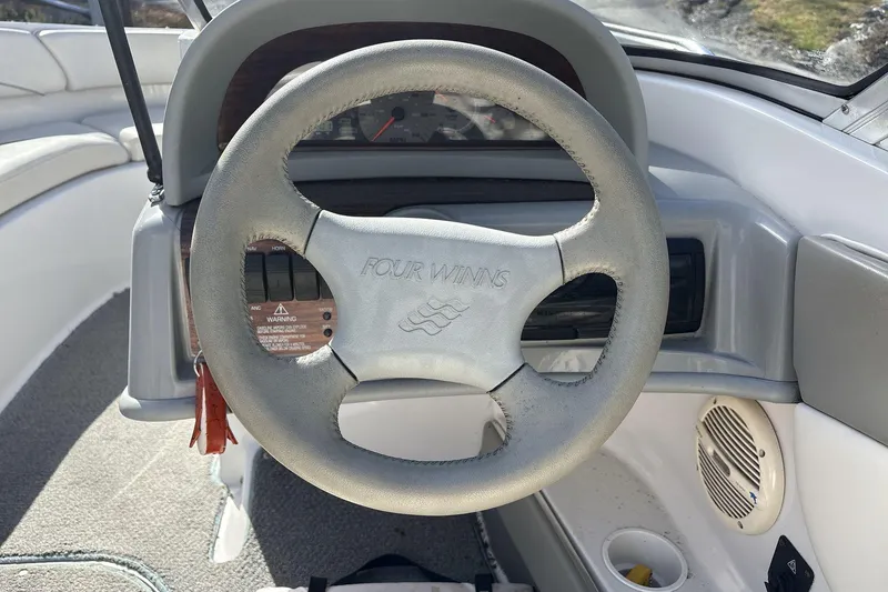 Slide: The Image of Steering wheel of 2001 Four Winns 180 Horizon boat, featuring dashboard controls. - 10