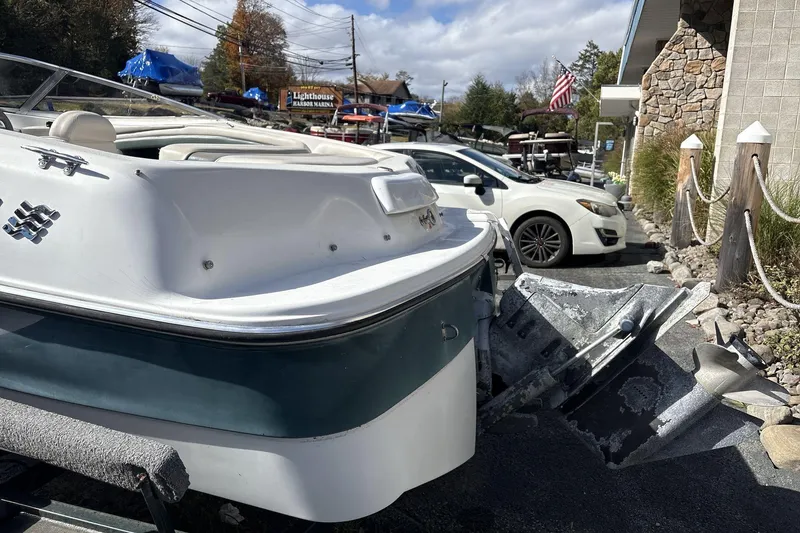 Slide: The Image of 2001 Four Winns 180 Horizon boat parked at marina with cars and American flag. - 5