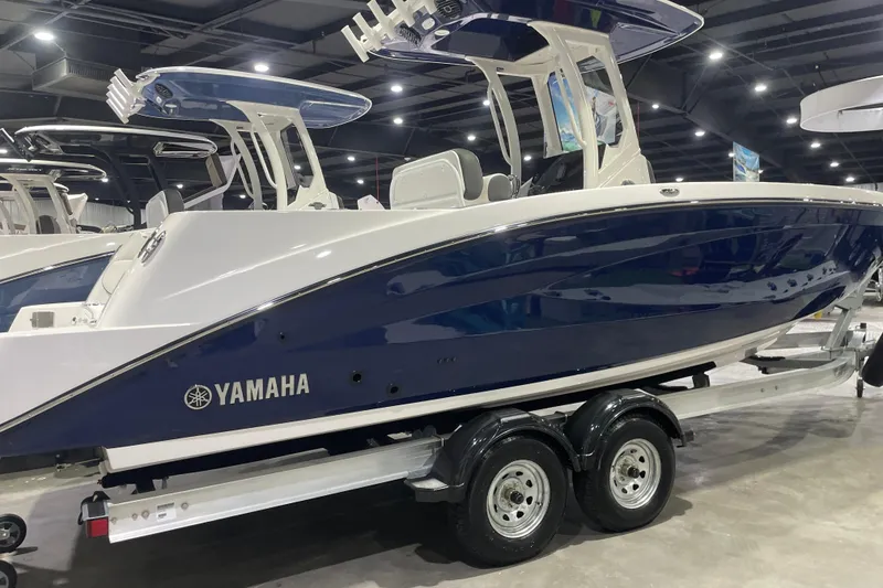 Slide: The Image of 2025 Yamaha Boats 255 FSH Sport H displayed indoors on a trailer. - 2