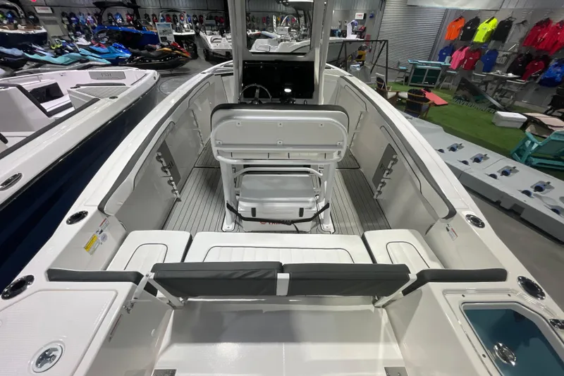 Slide: The Image of 2025 Yamaha Boats 255 FSH Sport H interior, showcasing seating and helm in showroom. - 5
