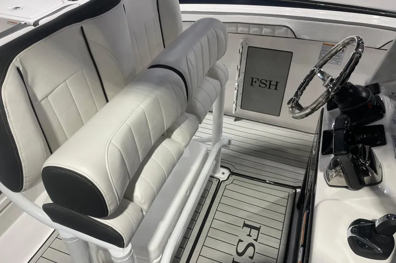Slide: The Image of 2025 Yamaha Boats 255 FSH Sport H interior with steering wheel and seating. - 7