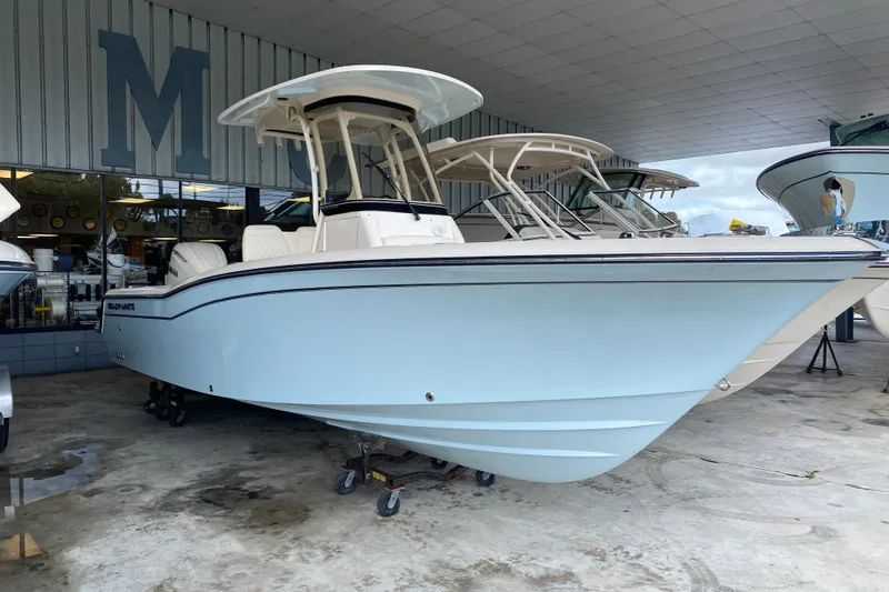 Slide: The Image of 2026 Grady-White Fisherman 236 boat displayed in a showroom, side view. - 2