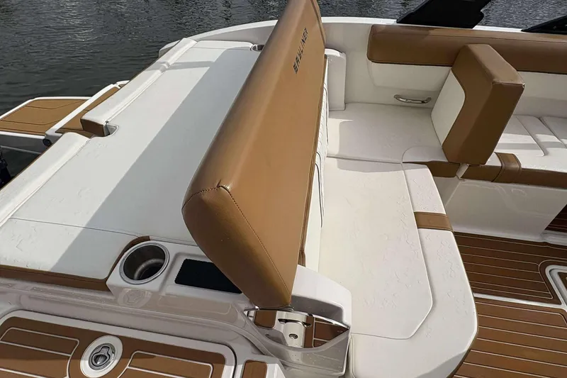 Slide: The Image of 2021 Bayliner DX 2000 boat interior with tan and white seating, cup holder, and water view. - 12