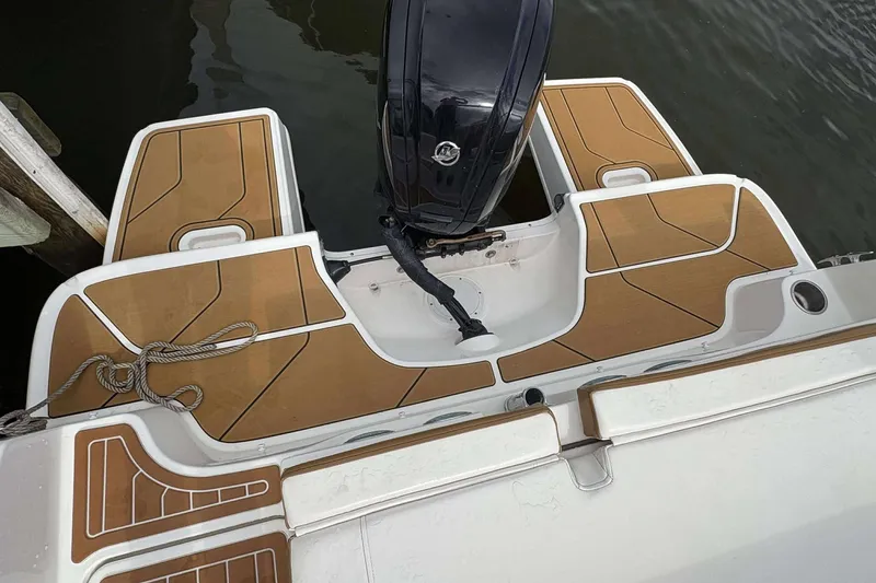 Slide: The Image of 2021 Bayliner DX 2000 boat stern with outboard motor and teak-style decking. - 14