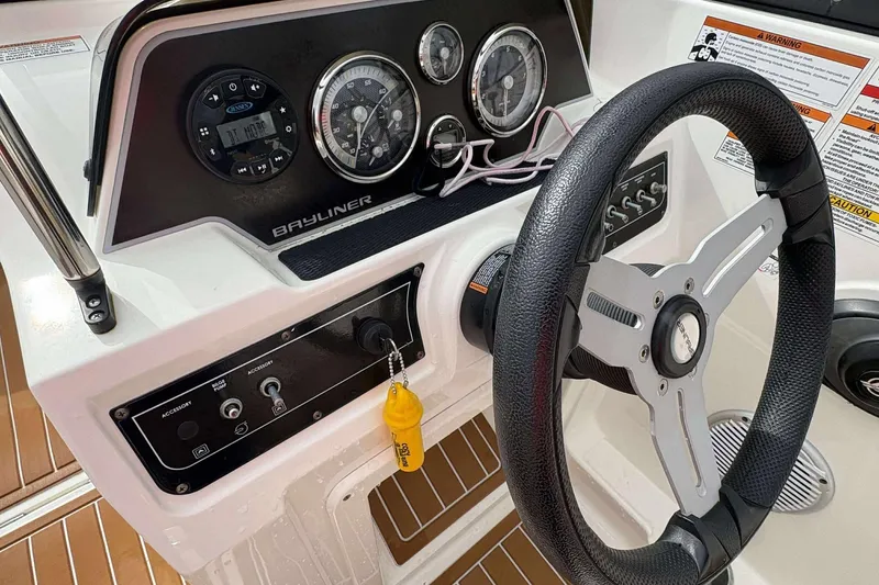 Slide: The Image of 2021 Bayliner DX 2000 boat dashboard with steering wheel and control panel. - 8