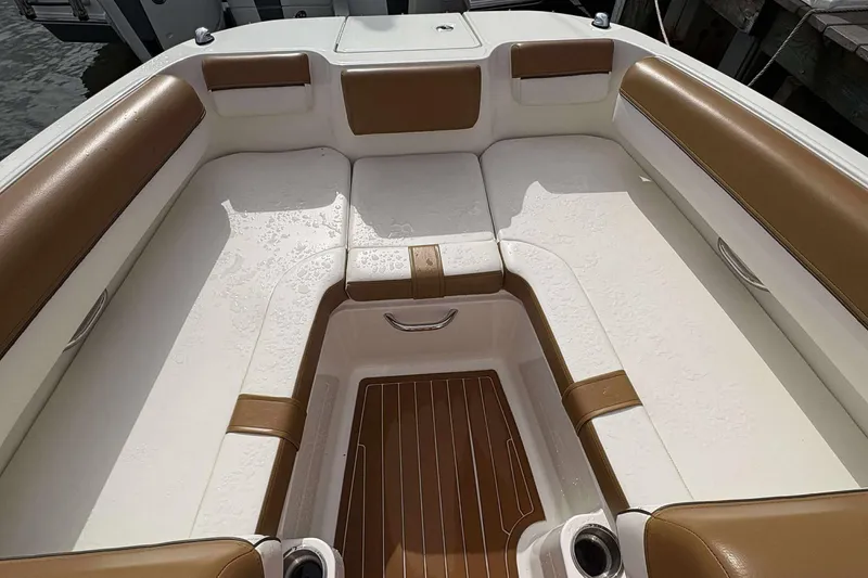 Slide: The Image of 2021 Bayliner DX 2000 boat interior with white and brown seating, wet with water droplets. - 9