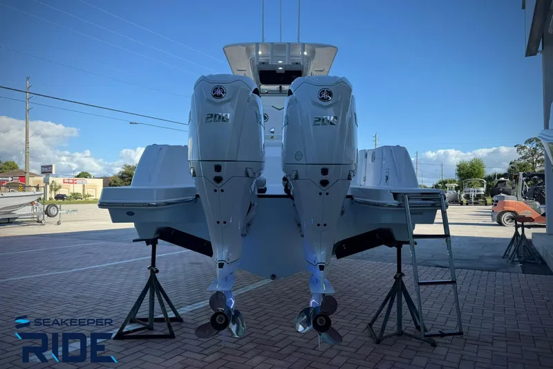 Slide: The Image of Edgewater 250CC 2026 boat with dual outboard engines on display in a sunny outdoor setting. - 10