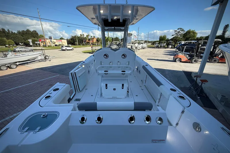 Slide: The Image of 2026 Edgewater 250CC boat interior with seating and storage, displayed outdoors. - 12