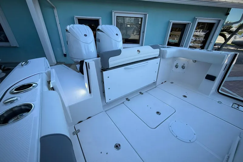 Slide: The Image of 2026 Edgewater 250CC boat deck with dual outboard motors and seating area. - 14