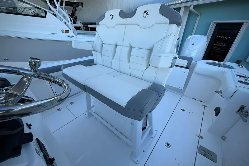 Slide: The Image of 2026 Edgewater 250CC boat interior with white and gray seating, steering wheel visible. - 26