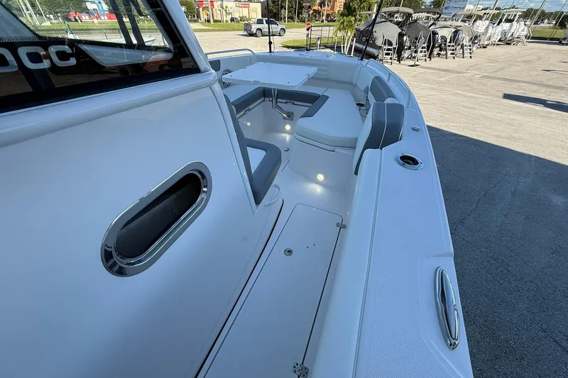 Slide: The Image of 2026 Edgewater 250CC boat interior with seating, table, and cup holders. - 29