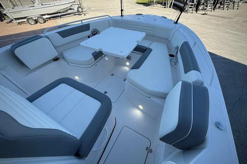 Slide: The Image of 2026 Edgewater 250CC boat interior with white and gray seating and a central table. - 33