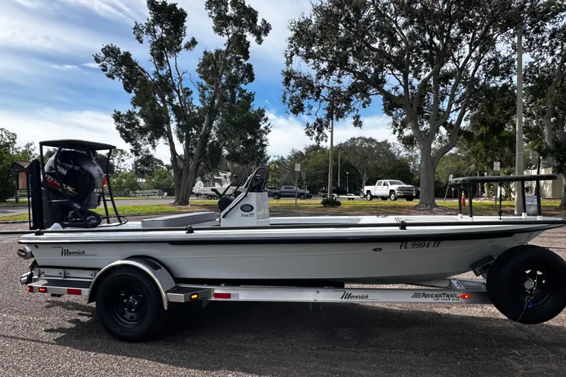 Slide: The Image of 2022 Maverick 17 HPX-V boat on trailer, parked outdoors with trees in background. - 5