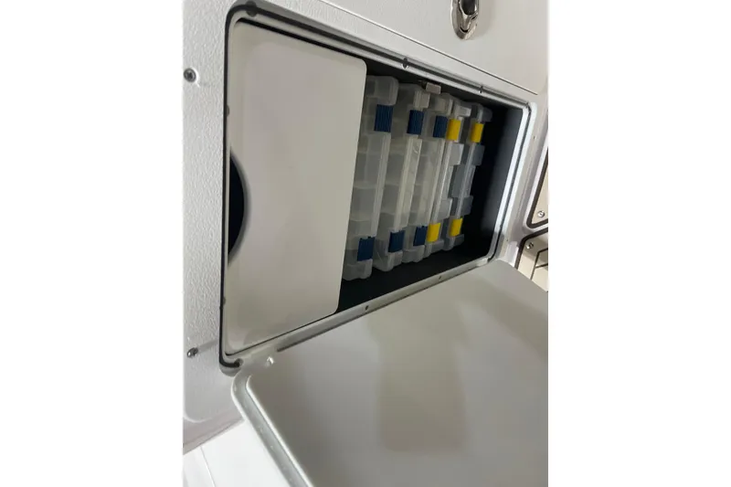 Slide: The Image of Storage compartment on 2025 Yamaha Boats 252 FSH Sport, featuring organized tackle boxes. - 12