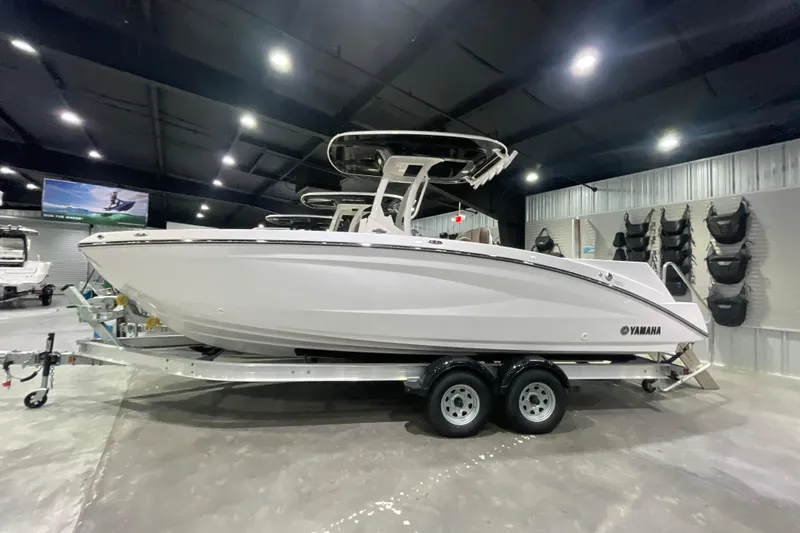 Slide: The Image of 2025 Yamaha Boats 252 FSH Sport displayed in a showroom on a trailer. - 2