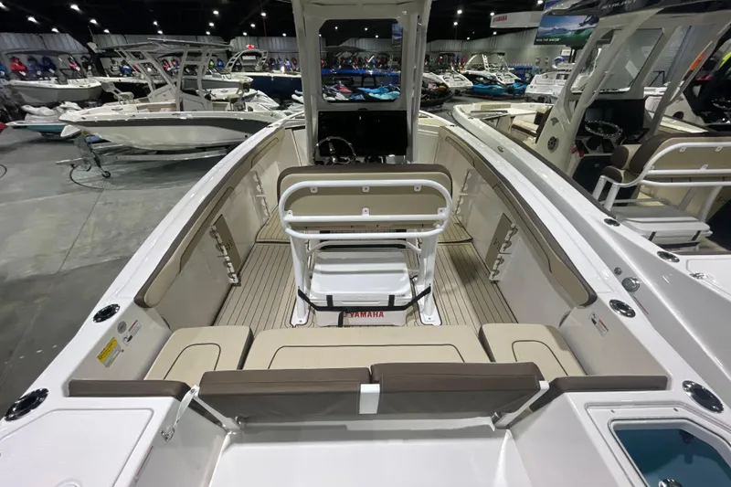 Slide: The Image of 2025 Yamaha Boats 252 FSH Sport interior at a boat show, showcasing seating and helm. - 5