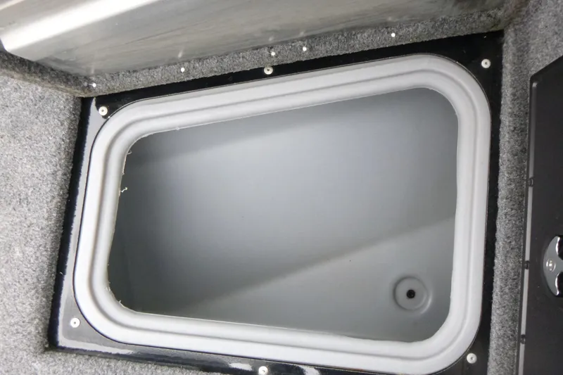 Slide: The Image of 2019 Tracker Pro Guide V-175 Combo storage compartment with gray interior and carpeted edges. - 10