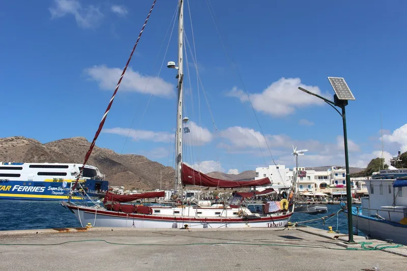 Slide: The Image of 1988 Tayana Vancouver 42 sailboat docked at a sunny marina with ferry in background. - 6