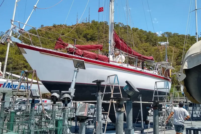 Slide: The Image of Sailboat Tayana Vancouver 42, 1988 model, docked for maintenance with red sails. - 7